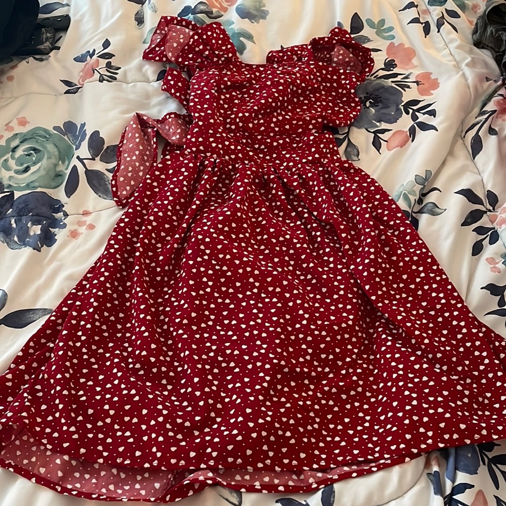 a red summer dress with white hearts shoes a little back